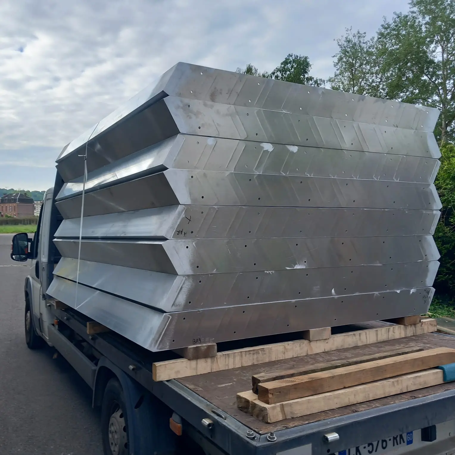 Transport de pièces métalliques pliées sur plateau