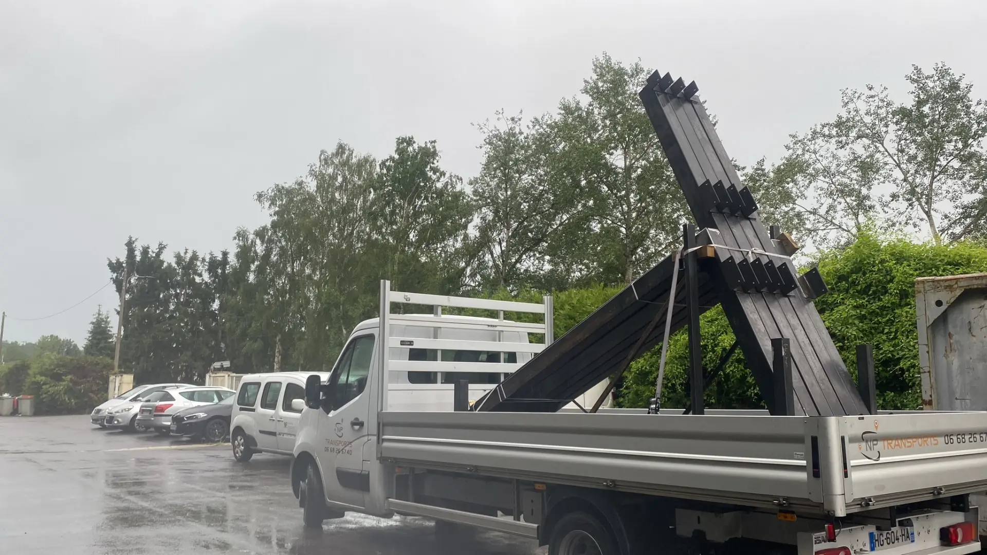 Poutres acier noires arrimées sur le camion sous la pluie