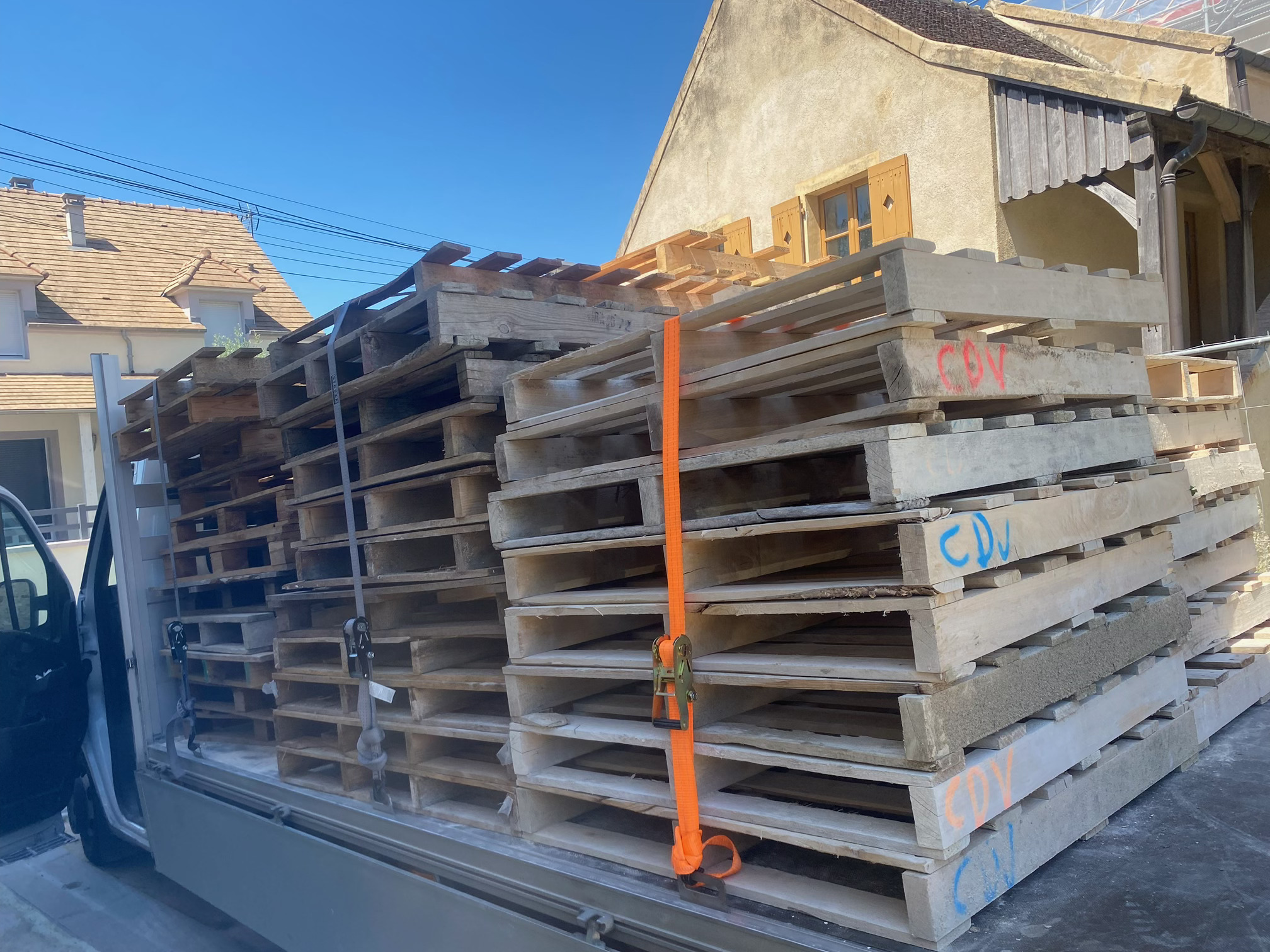 Palettes bois empilées et sanglées sur le plateau